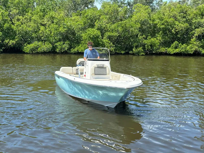 Slide: The Image of 2025 Key West 189 FS boat cruising on a calm river with lush greenery. - 2