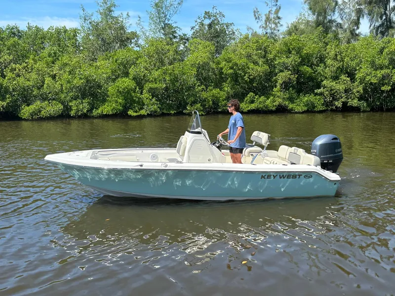 Slide: The Image of 2025 Key West 189 FS boat cruising on a calm river with lush greenery. - 3