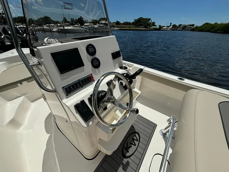 Slide: The Image of 2025 Key West 189 FS boat interior with steering wheel and control panel by the water. - 5