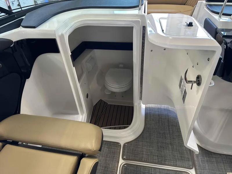 Slide: The Image of 2025 Sea Ray 280SLX boat interior with open bathroom door, showcasing compact toilet. - 8