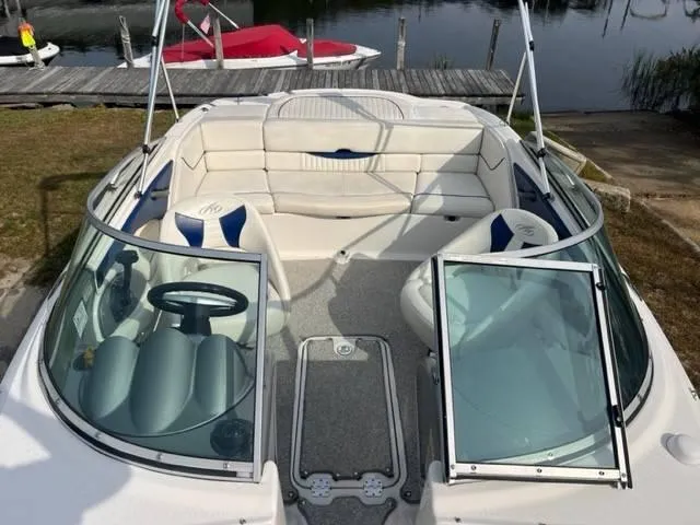 Slide: The Image of 2005 Monterey 194 FS boat with open seating and steering wheel, docked by the water. - 6