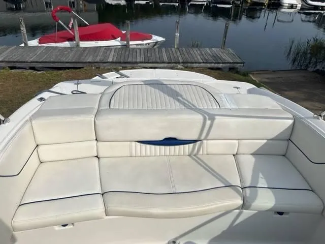 Slide: The Image of 2005 Monterey 194 FS boat with white seating, docked near a calm marina. - 9