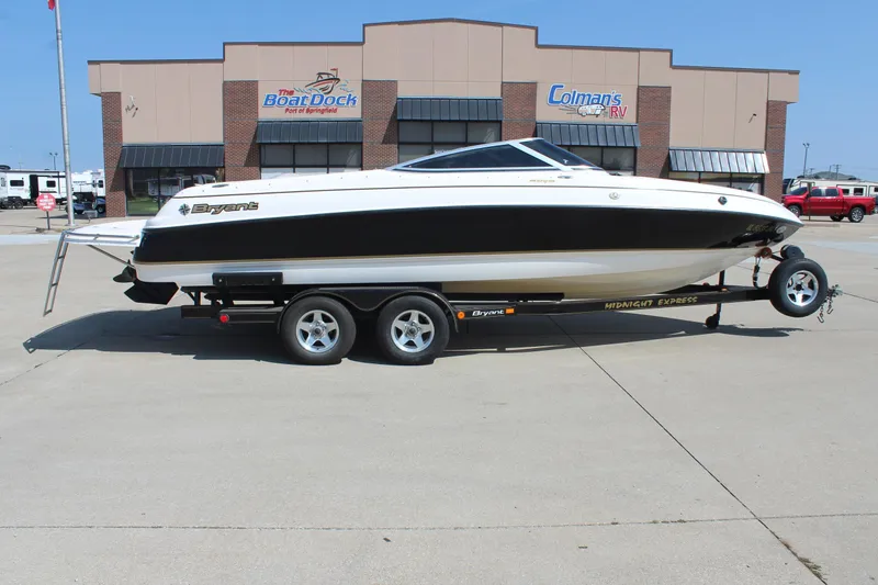 The Image of 2002 Bryant 234 boat on trailer in front of dealership. - 1