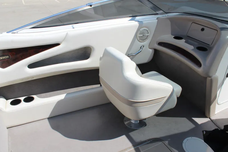 Slide: The Image of Interior of a 2002 Bryant 234 boat with white seating and dashboard. - 11