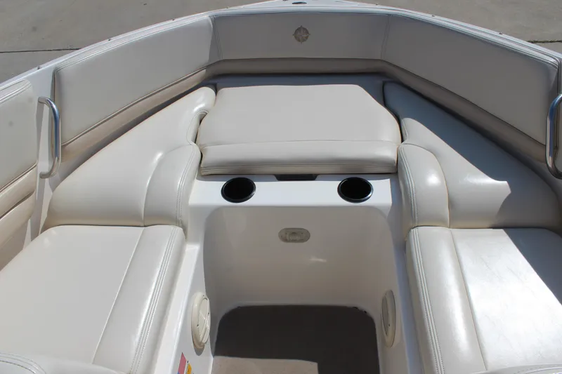 Slide: The Image of 2002 Bryant 234 boat interior with white seating and cup holders. - 12
