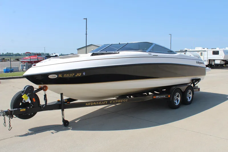 Slide: The Image of 2002 Bryant 234 boat on trailer, parked outdoors, with "Midnight Express" branding. - 3