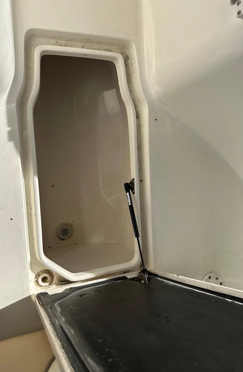 Slide: The Image of 2019 Key West 244 Center Console storage compartment with open hatch. - 29