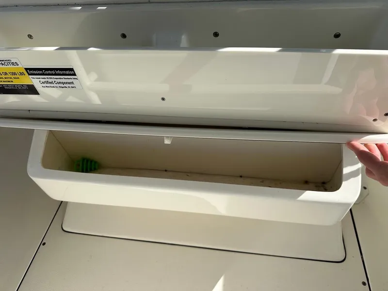 Slide: The Image of 2019 Key West 244 Center Console storage compartment with open lid. - 40