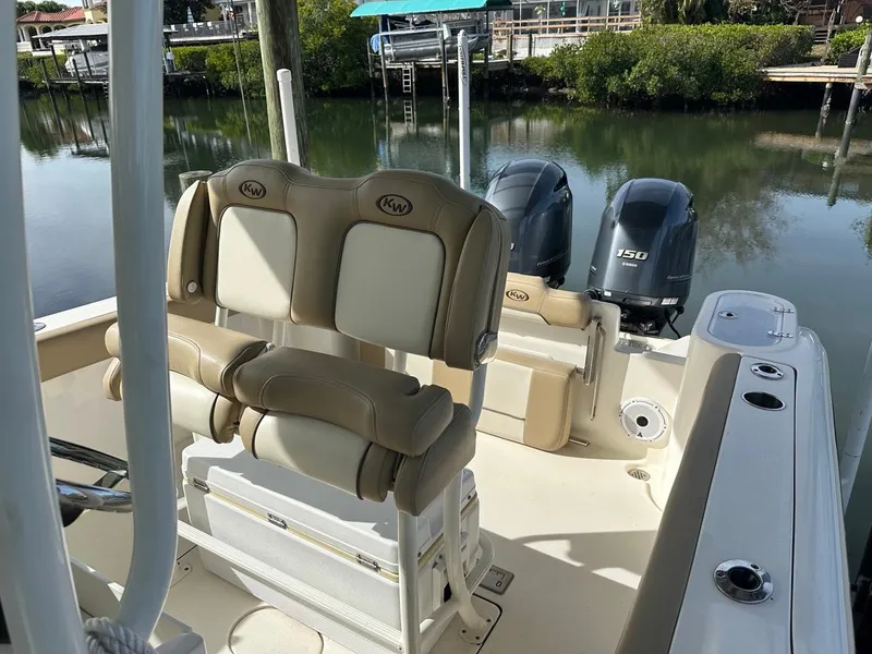 Slide: The Image of 2019 Key West 244 Center Console boat with dual engines, docked by a serene waterfront. - 42