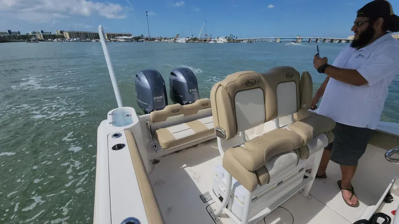 Slide: The Image of 2019 Key West 244 Center Console boat on water, with person standing near helm. - 46