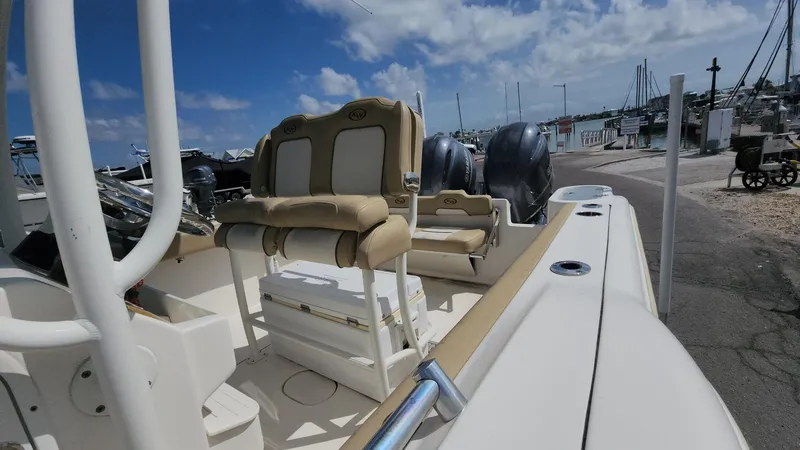 Slide: The Image of 2019 Key West 244 Center Console boat at marina, featuring dual seats and outboard motors. - 48