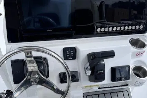 Slide: The Image of 2025 Tidewater 220 CC Adventure boat dashboard with steering wheel and controls. - 13