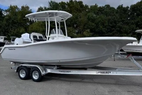 Slide: The Image of 2025 Tidewater 220 CC Adventure boat on trailer, parked outdoors. - 2