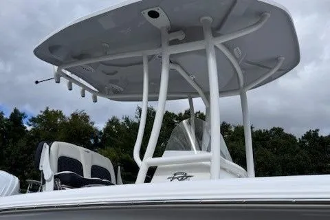 Slide: The Image of 2025 Tidewater 220 CC Adventure boat with T-top and seating, under cloudy sky. - 5