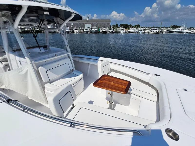 Slide: The Image of 2022 Southport 30 FE boat with seating and table, docked at marina. - 2