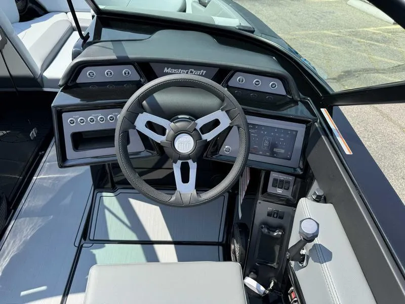Slide: The Image of 2025 MasterCraft NXT22 boat dashboard with steering wheel and control panel. - 11
