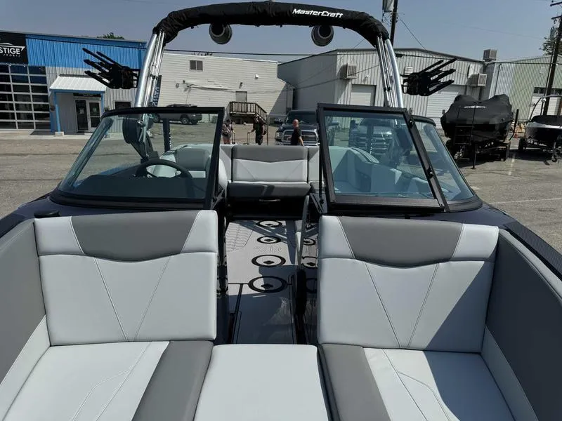 Slide: The Image of 2025 MasterCraft NXT22 boat interior with gray seating and open windshield. - 13