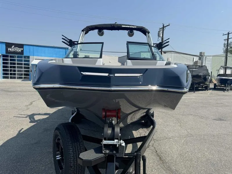 Slide: The Image of 2025 MasterCraft NXT22 boat on trailer, front view, parked at dealership. - 3