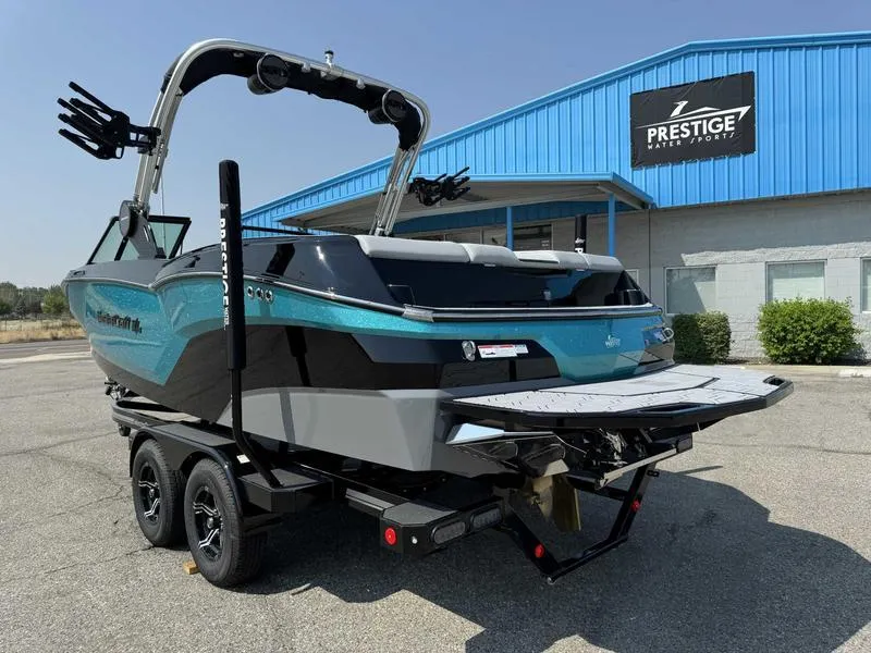 Slide: The Image of 2025 MasterCraft NXT22 boat at Prestige dealership, featuring sleek design and dual-axle trailer. - 4