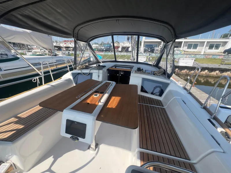 Slide: The Image of 2021 Dufour 360 sailboat cockpit with wooden seating and canopy. - 10