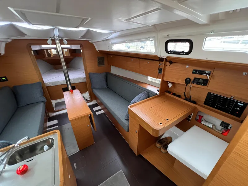 Slide: The Image of Interior of 2021 Dufour 360 yacht, featuring modern wood finish and cozy seating area. - 24