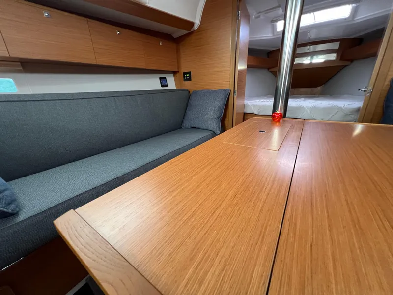 Slide: The Image of Interior of 2021 Dufour 360 yacht with wooden table and gray seating. - 38