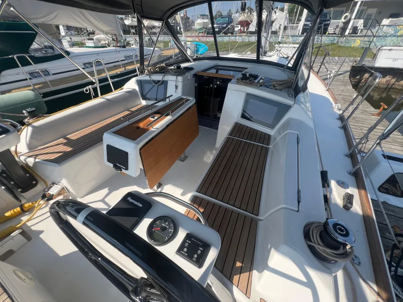 Slide: The Image of Dufour 360 sailboat cockpit, 2021 model, featuring modern navigation equipment and wooden seating. - 7