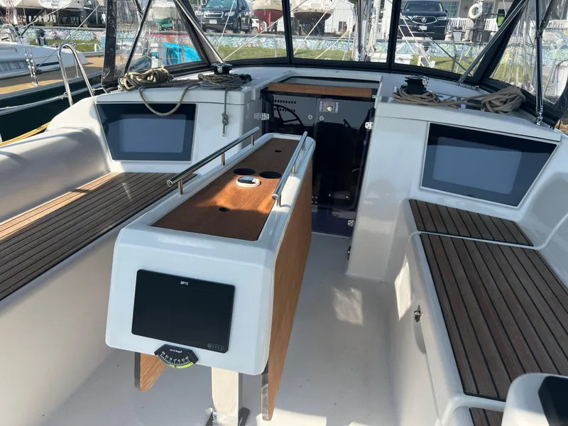 Slide: The Image of 2021 Dufour 360 yacht cockpit with modern navigation equipment and wooden seating. - 9