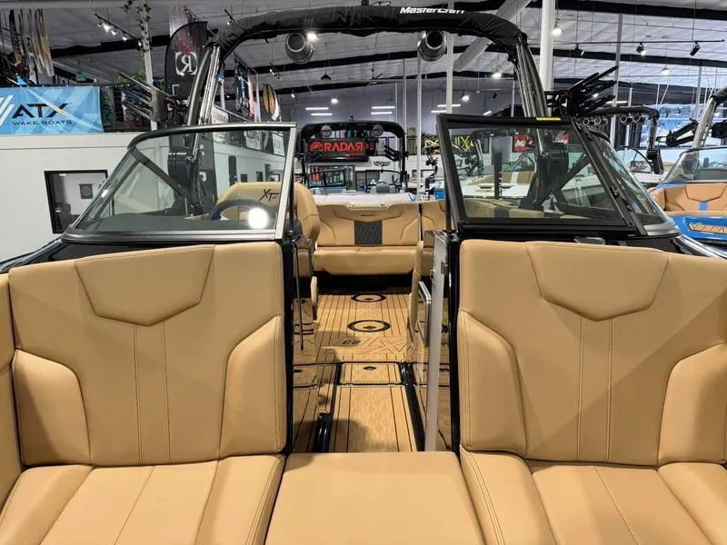 Slide: The Image of 2025 MasterCraft XT23 boat interior with tan leather seats and sleek design. - 11