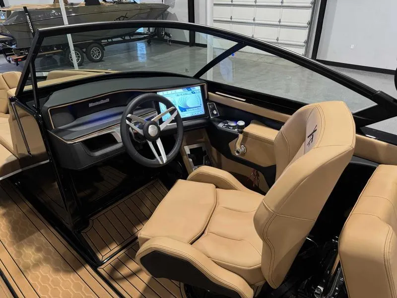 Slide: The Image of 2025 MasterCraft XT23 boat interior with modern dashboard and tan seating. - 12