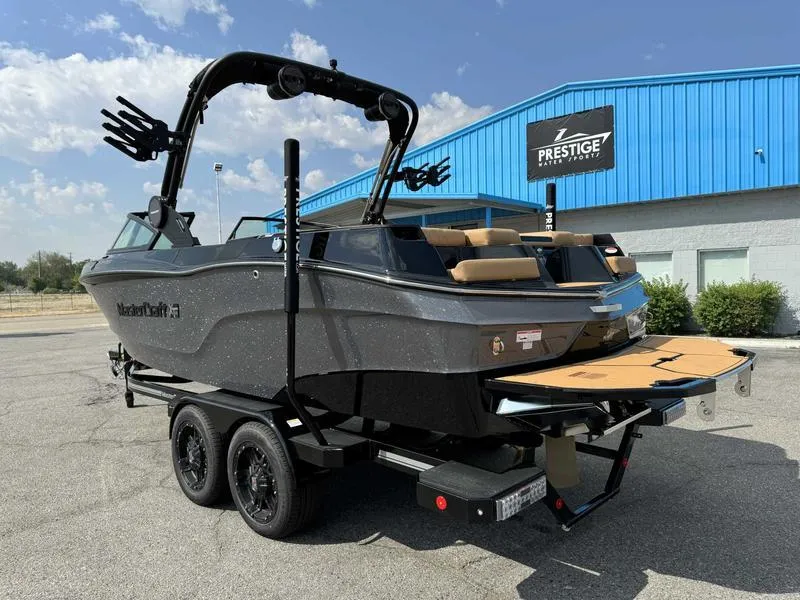 Slide: The Image of 2025 MasterCraft XT23 boat on trailer, parked outside Prestige building. - 4