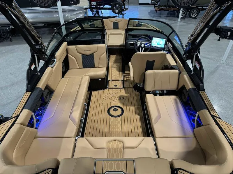 Slide: The Image of 2025 MasterCraft XT23 boat interior with tan seating and modern dashboard. - 6