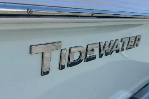 Slide: The Image of 2025 Tidewater 180 CC Adventure boat logo on white hull. - 8