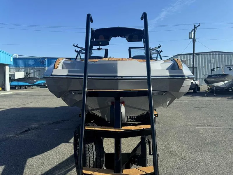 Slide: The Image of 2025 Supra SE boat on trailer in industrial area, clear blue sky. - 5