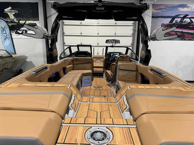 Slide: The Image of 2025 Supra SE boat interior with luxurious tan seating and sleek design in a showroom setting. - 9