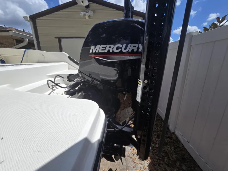 Slide: The Image of 2022 Bayliner Trophy T20CC with Mercury outboard motor, parked near a shed. - 21