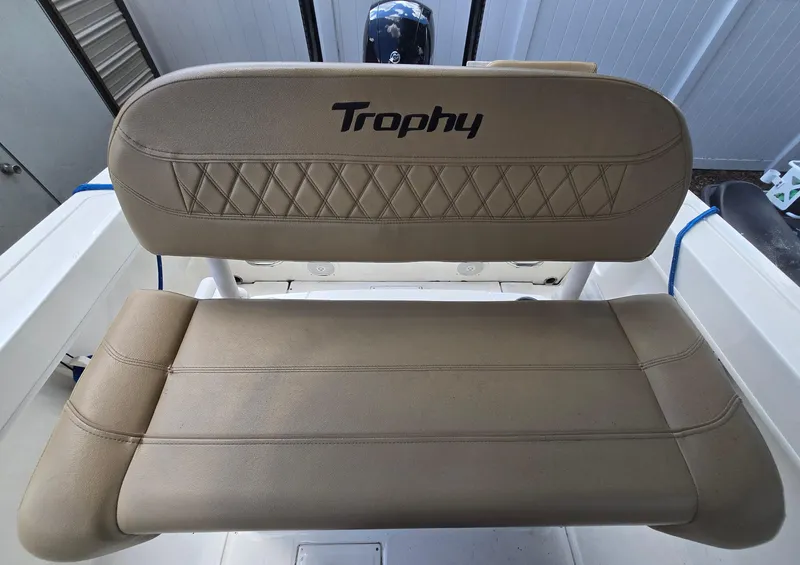 Slide: The Image of 2022 Bayliner Trophy T20CC boat seat with "Trophy" logo, beige upholstery. - 43