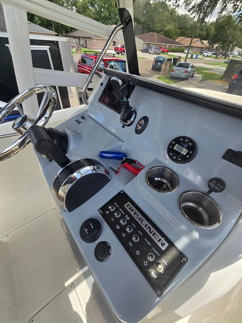 Slide: The Image of 2022 Bayliner Trophy T20CC boat dashboard with steering wheel and controls. - 48