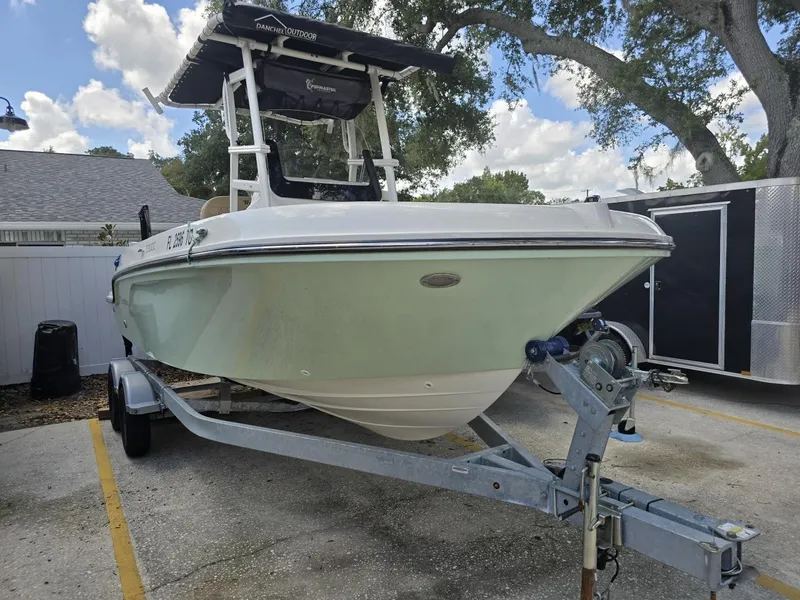 Slide: The Image of 2022 Bayliner Trophy T20CC boat on trailer, parked outdoors under a cloudy sky. - 6