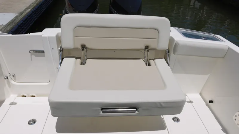 Slide: The Image of 2024 Boston Whaler 280 Vantage boat seat, white and beige upholstery, docked. - 12