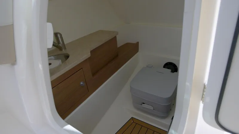 Slide: The Image of 2024 Boston Whaler 280 Vantage boat interior with compact bathroom and sink. - 7