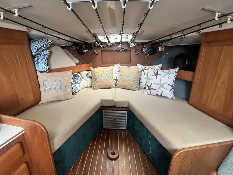 Slide: The Image of 1995 Luhrs 320 Open cabin interior with cozy seating and decorative pillows. - 15