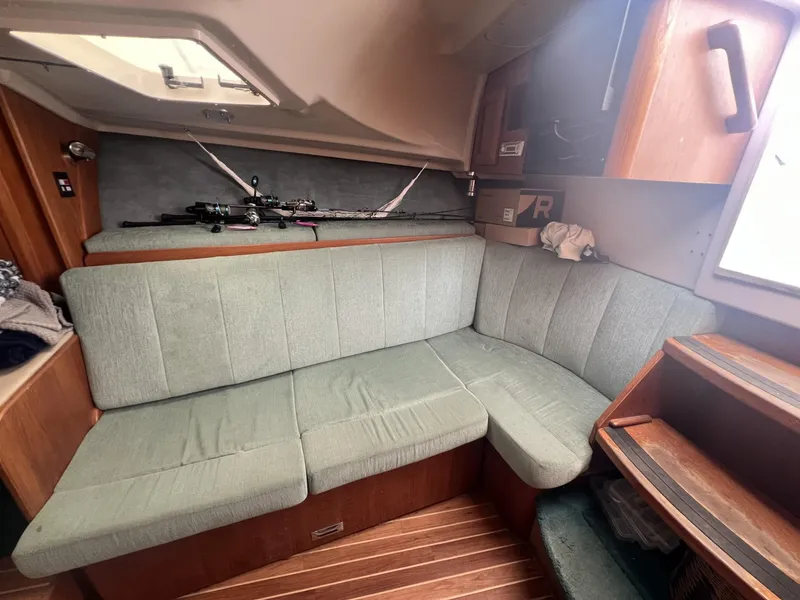 Slide: The Image of 1995 Luhrs 320 Open cabin interior with green seating and fishing rods. - 16