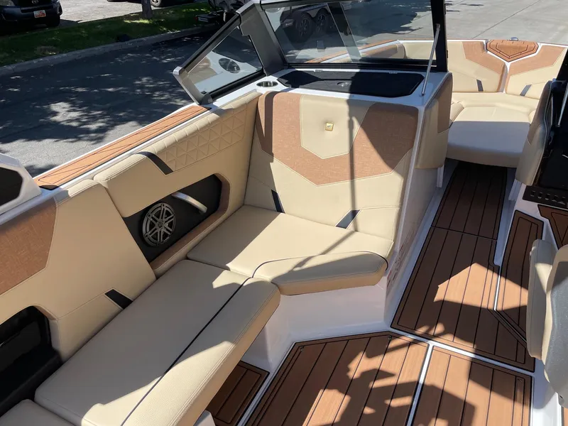 Slide: The Image of 2025 Nautique Super Air Nautique GS22 interior with beige seating and wood accents. - 10