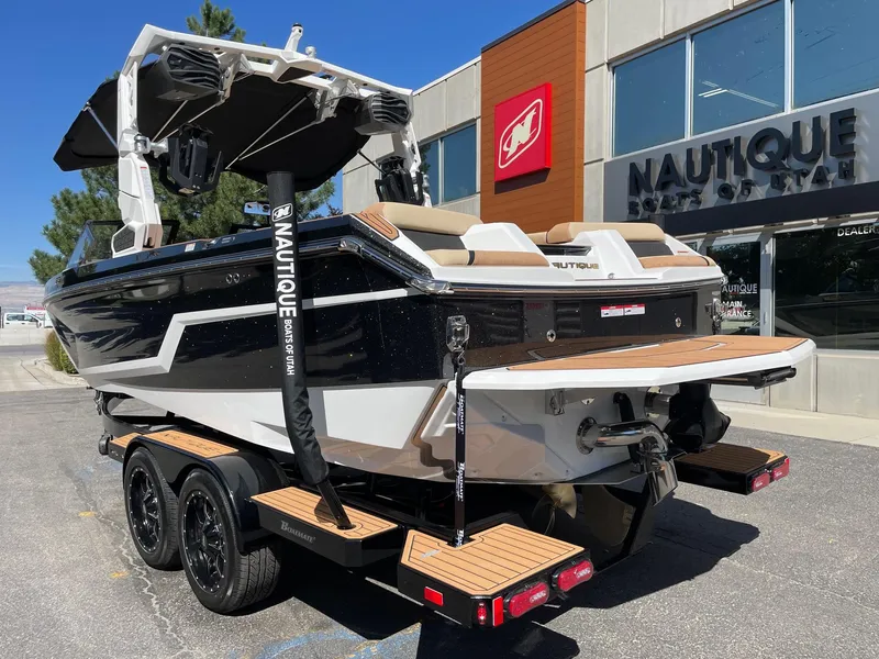Slide: The Image of 2025 Nautique Super Air Nautique GS22 boat on trailer outside dealership. - 3