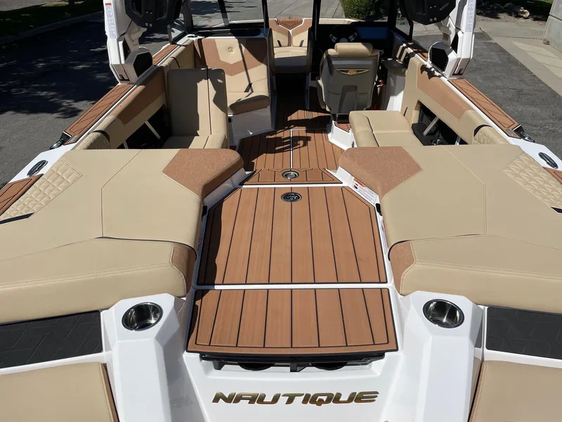 Slide: The Image of 2025 Nautique Super Air Nautique GS22 interior with tan seating and teak-style flooring. - 4