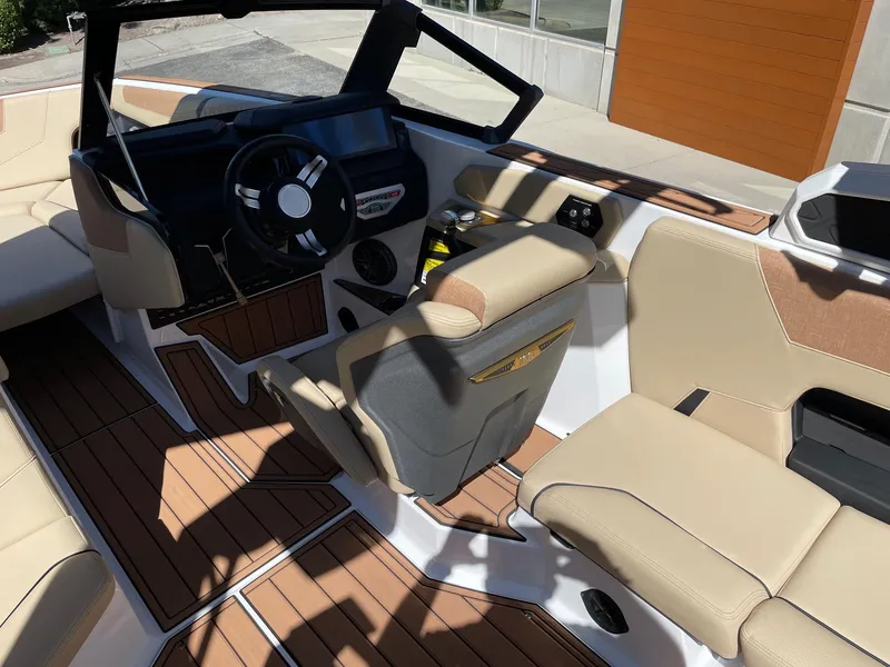 Slide: The Image of 2025 Nautique Super Air Nautique GS22 interior with beige seating and modern dashboard. - 6