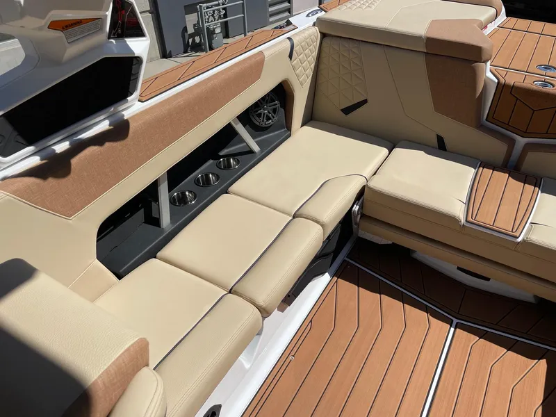 Slide: The Image of 2025 Nautique Super Air Nautique GS22 interior with beige seating and wood accents. - 7