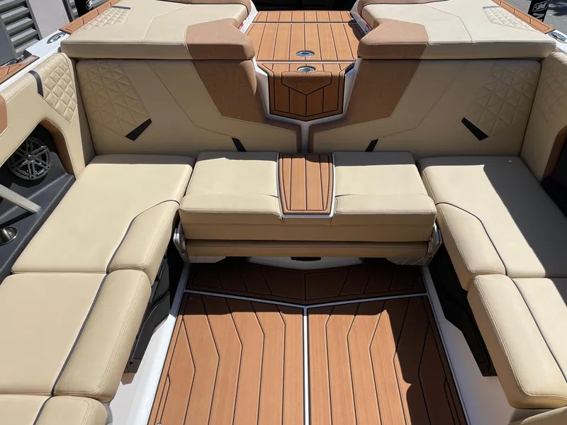Slide: The Image of 2025 Nautique Super Air Nautique GS22 interior with beige seating and teak flooring. - 8