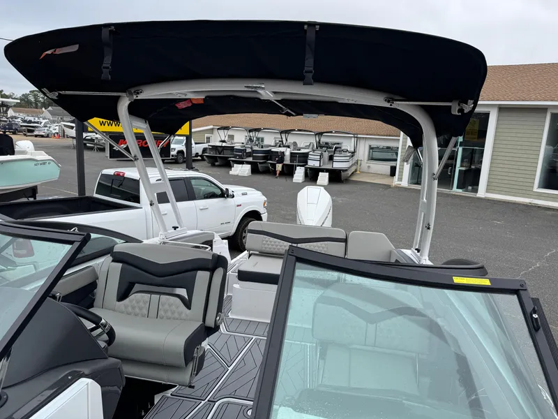Slide: The Image of 2025 Monterey 255 Super Sport boat with sleek interior and canopy, parked outdoors. - 3